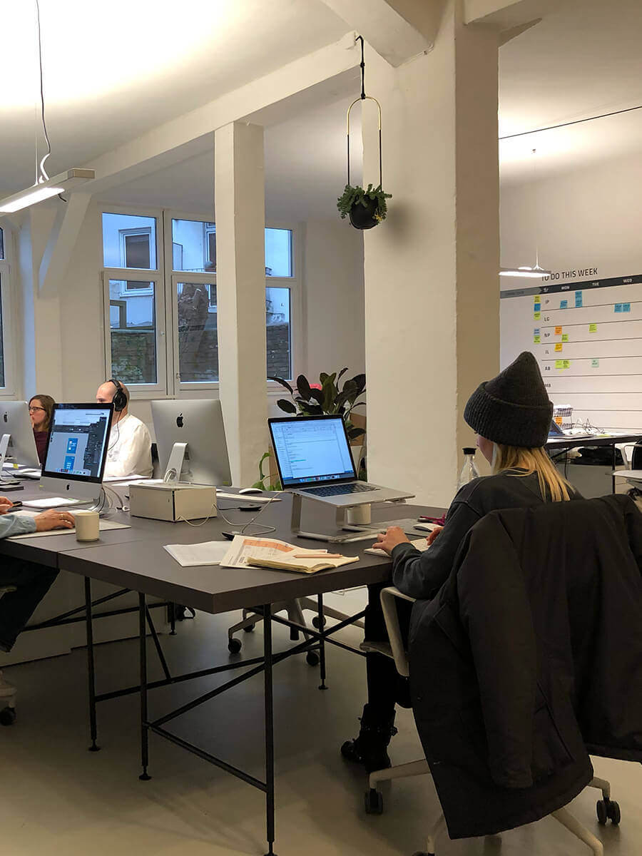 Blick in die modern eingerichtete Agentur mit schwarzen Tischen